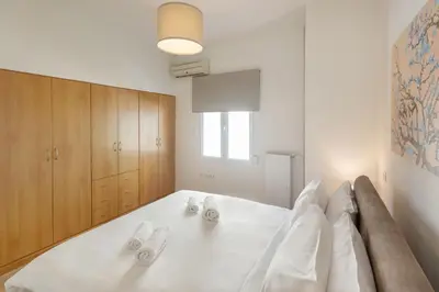 a bedroom with a large white bed with two towels at Acropolis Museum Retreat by GHH in Athens