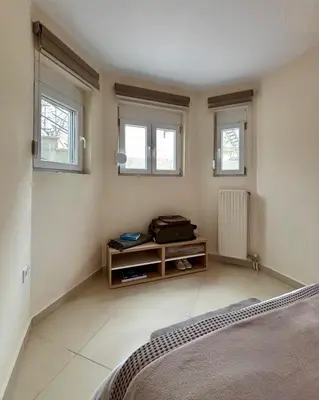 a bedroom with a bed and three windows at Pearl Villa and Apartment near Beach and Athens Airport in Porto Rafti