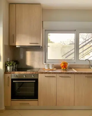 a kitchen with a window and a sink and a stove at Pearl Villa and Apartment near Beach and Athens Airport in Porto Rafti