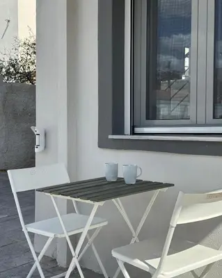 a table and two chairs sitting next to a window at Pearl Villa and Apartment near Beach and Athens Airport in Porto Rafti