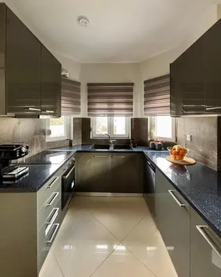 a kitchen with black cabinets and a bowl of fruit on the counter at Pearl Villa and Apartment near Beach and Athens Airport in Porto Rafti