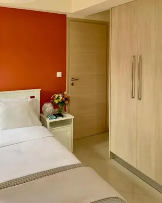 a bedroom with a bed and a door with flowers on a table at Pearl Villa and Apartment near Beach and Athens Airport in Porto Rafti