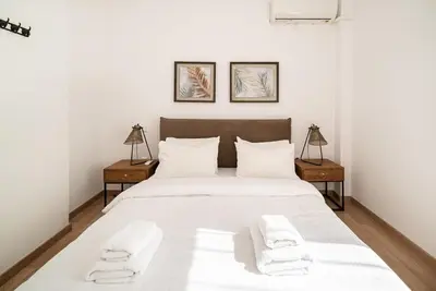 a bedroom with a large white bed with two night stands at Athens Due Montagne Apartment in Athens