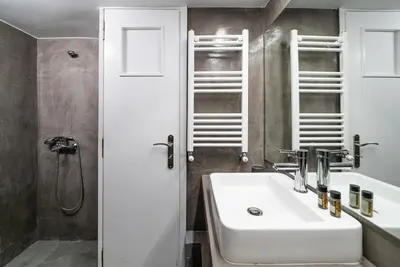 a bathroom with a white sink and a shower at Athens Due Montagne Apartment in Athens