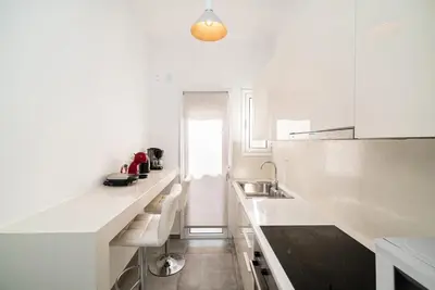 a white kitchen with white counters and a sink at Athens Due Montagne Apartment in Athens