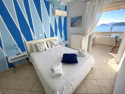 a bedroom with a bed with a view of the ocean at MediTerra Stay Anavyssos Seaview in Áyios Yeóryios