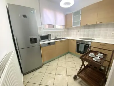 a kitchen with a refrigerator and a table in it at MediTerra Stay Anavyssos Seaview in Áyios Yeóryios