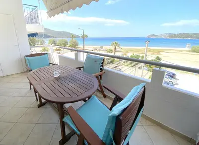 a table and chairs on a balcony with a view of the beach at MediTerra Stay Anavyssos Seaview in Áyios Yeóryios
