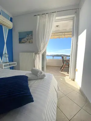 a bedroom with a bed and a view of the ocean at MediTerra Stay Anavyssos Seaview in Áyios Yeóryios
