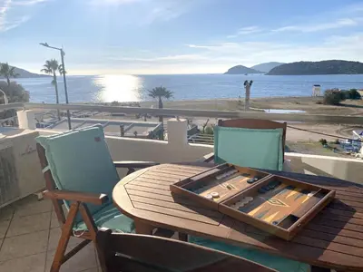 a wooden table and chairs with a view of the ocean at MediTerra Stay Anavyssos Seaview in Áyios Yeóryios