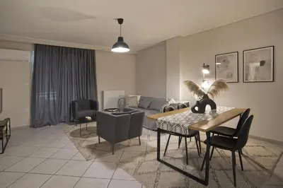 a living room with a couch and a table and chairs at Denimou Home Luxurious 2BR Fully Equipped, Balcony in Piraeus