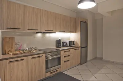 a kitchen with wooden cabinets and a stove top oven at Denimou Home Luxurious 2BR Fully Equipped, Balcony in Piraeus
