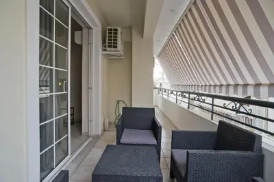 a balcony with two chairs and a railing at Denimou Home Luxurious 2BR Fully Equipped, Balcony in Piraeus