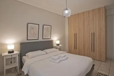 a bedroom with a bed with towels on it at Denimou Home Luxurious 2BR Fully Equipped, Balcony in Piraeus