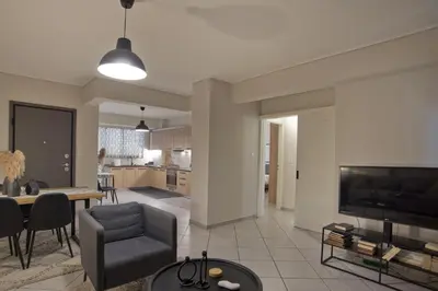 a living room with a couch a table and a television at Denimou Home Luxurious 2BR Fully Equipped, Balcony in Piraeus