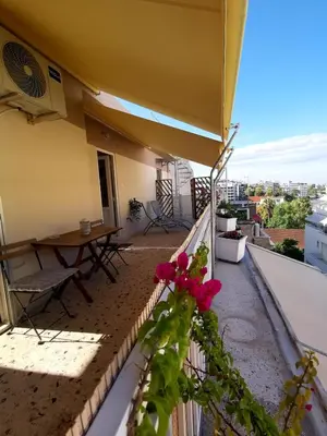 a balcony of a building with a table and flowers at Downtown Cozy penthouse For balcony lovers in Athens