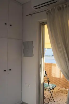 a room with a window and a chair and a curtain at Downtown Cozy penthouse For balcony lovers in Athens