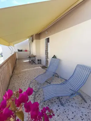 two chairs sitting on a balcony with pink flowers at Downtown Cozy penthouse For balcony lovers in Athens