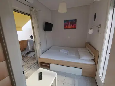 a small bedroom with a bed and a table at Downtown Cozy penthouse For balcony lovers in Athens