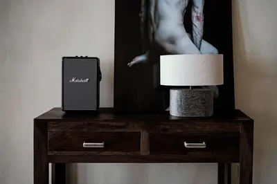 a nightstand with a cell phone and a lamp on it at Luxurious loft in Monastiraki in Athens