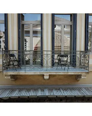 a balcony with tables and chairs on a building at Luxurious loft in Monastiraki in Athens
