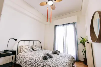 a bedroom with a bed with a ceiling fan and a window at Happy Rabbit 4 in Athens