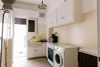 a kitchen with white cabinets and a washer and dryer at Happy Rabbit 4 in Athens