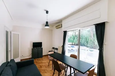 a living room with a table and a large window at Happy Rabbit 4 in Athens