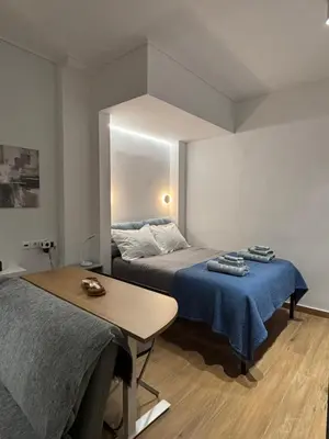 a bedroom with two beds and a table and a mirror at Elegant City Retreat Walk to Landmarks & Metro in Athens