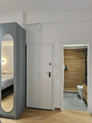 a bedroom with a white door and a bed and a mirror at Elegant City Retreat Walk to Landmarks & Metro in Athens