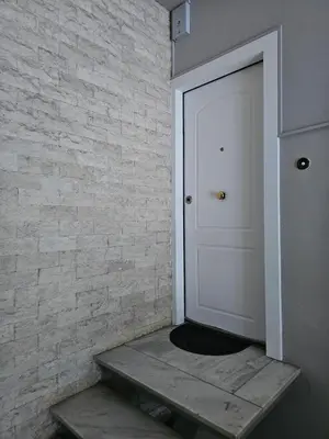 a white door in a room with a brick wall at Elegant City Retreat Walk to Landmarks & Metro in Athens