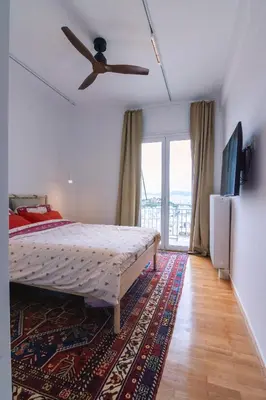a bedroom with a bed and a ceiling fan at Spacious Apartment in Lycabettus Hill in Athens