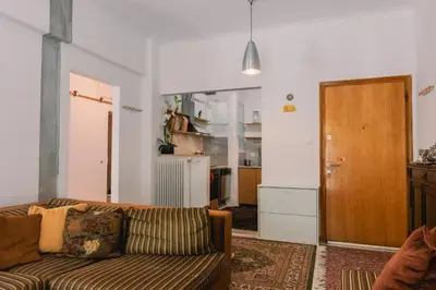 a living room with a couch and a kitchen at Spacious Apartment in Lycabettus Hill in Athens