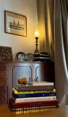 a stack of books sitting on top of a dresser at Spacious Apartment in Lycabettus Hill in Athens