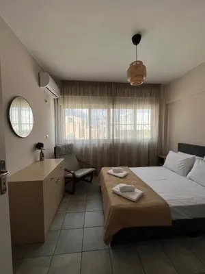 a bedroom with a bed and a chair and a table at Nina's Home in Athens