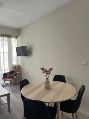 a dining room table with a vase of flowers on it at Nina's Home in Athens