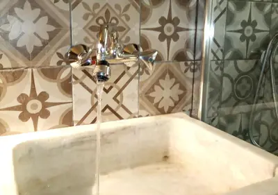 a bath tub with water running from a faucet at OneStep in Athens by Oinapothiki Taverna! in Athens