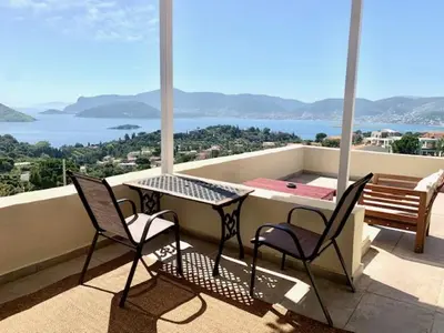 a balcony with a table and two chairs and a bench at Ersi's View in Porto Rafti