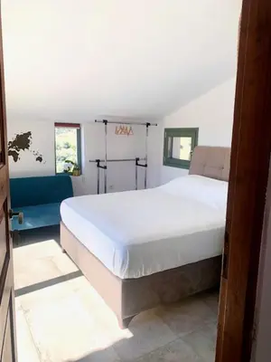 a bedroom with a large white bed and two windows at Ersi's View in Porto Rafti