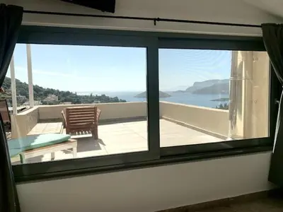 a room with a view of the ocean through a window at Ersi's View in Porto Rafti