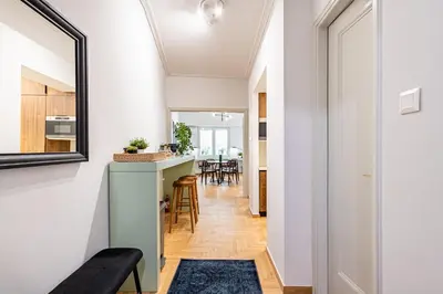 a kitchen and dining room with white walls and a mirror at STELLIE Elegant Mid-century modern 2bd-2bath in Athens