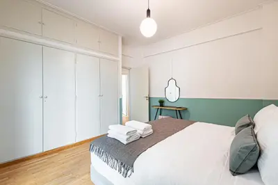 a bedroom with a white bed with towels on it at STELLIE Elegant Mid-century modern 2bd-2bath in Athens