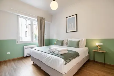 a bedroom with a bed with green and white at STELLIE Elegant Mid-century modern 2bd-2bath in Athens
