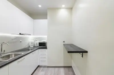 a white kitchen with a sink and a counter at Centrally Located Apt for 3 People in Athens
