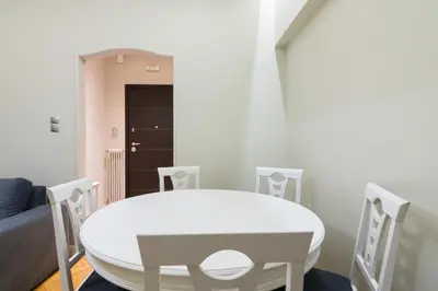 a white dining room with a white table and chairs at Centrally Located Apt for 3 People in Athens