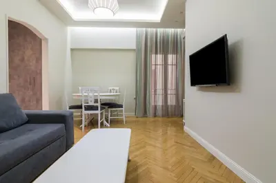 a living room with a couch and a tv on a wall at Centrally Located Apt for 3 People in Athens