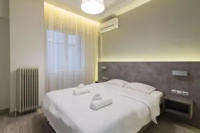 a bedroom with a large white bed with towels on it at Centrally Located Apt for 3 People in Athens
