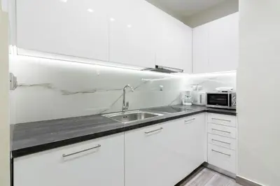 a white kitchen with a sink and a microwave at Centrally Located Apt for 3 People in Athens