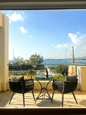 two chairs and a table on a balcony with a view at Serene Seaside Villa Raf with Unique Sunset View in Nisídhes Markéllou