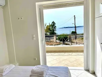 a bedroom with a bed and a view of the ocean at Serene Seaside Villa Raf with Unique Sunset View in Nisídhes Markéllou